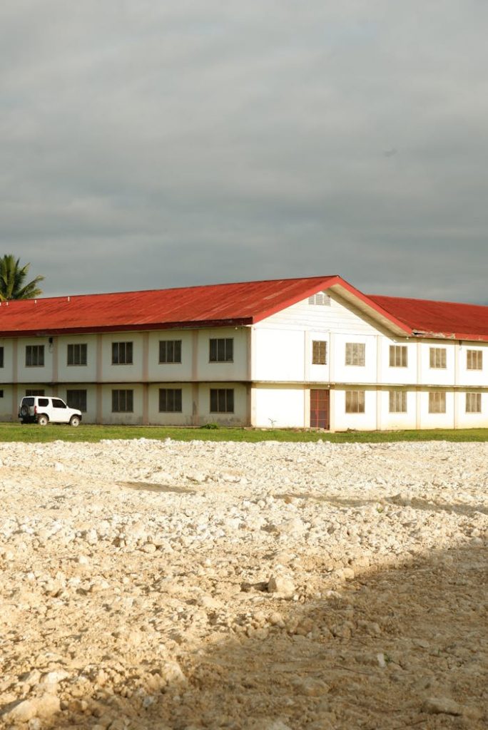 A white building with a red roof under cloudy skies in Valencia City, Philippines.